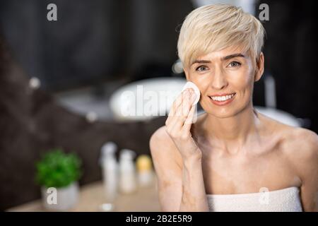 Lady Utilisation Des Tampons En Coton Retrait Quotidien Maquillage Dans La Salle De Bains Intérieur Banque D'Images