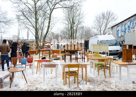 Les gens qui magasinent des meubles vintage d'occasion, des vêtements et des aliments montrent sur le sol couvert de neige à Fleamarket à Mauerpark à Berlin, en Allemagne. Banque D'Images