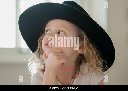 portrait d'une jeune fille avec son visage peint et chapeau de robe fantaisie Banque D'Images