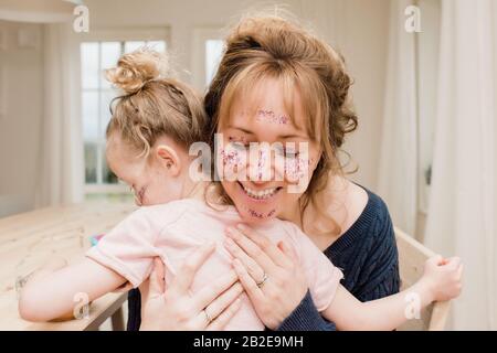 mère fille qui garde le corps avec maquillage et paillettes Banque D'Images