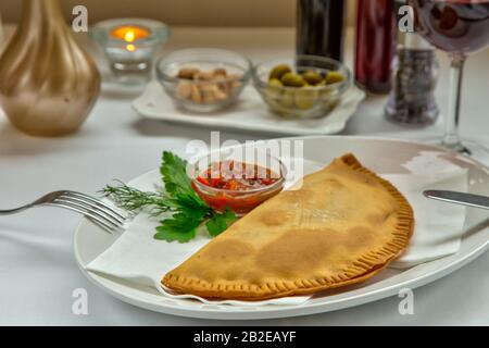 La nourriture traditionnelle pour tatar de Crimée est servie avec de la viande hachée servie avec de la crème aigre sur une plaque blanche. Banque D'Images