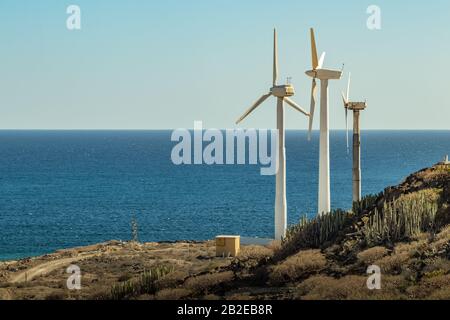 Centrales éoliennes. Une rangée de turbines près du bord de mer. Champ écologique du parc éolien. Parc Eolic avec ciel bleu en arrière-plan. Vert, écologique et de puissance ene Banque D'Images