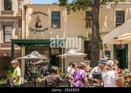 Sydney, Australie - 11 décembre 2009: La Renaissance Patisserie bâtiment jaune dans le quartier de Rocks avec scène de marché de rue. Une végétation verte Banque D'Images