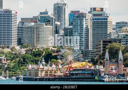 Sydney, Australie - 11 décembre 2009 : immeubles de bureaux en hauteur de North Sydney behindLuna Park, attractions sous le ciel argenté et au-dessus d'azure ba Banque D'Images