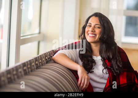 Portrait of a young woman enveloppé dans une couverture chaude. Banque D'Images
