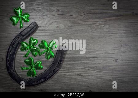 Fond avec fer à cheval rouillé, rochers sur bois rustique. Symbole de Saint-Patrick pour les jours fériés. Charmes chanceux. Vue de dessus, espace de copie. Banque D'Images