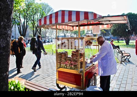 Istanbul, Turquie - le simili emblématique d'Istanbul (pain rond en croûte de sésame) est vendu par un vendeur sur la place Sultanahmet. Cuisine de rue et de base turque. Banque D'Images