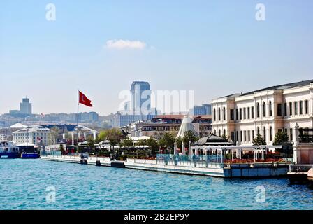 Istanbul, TURQUIE : le palais de Ciragan était autrefois le palais des sultans ottomans et est maintenant un hôtel de luxe. Hôtel vu du détroit du Bosphore avec drapeau turc Banque D'Images