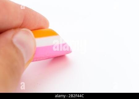 gomme dans une main isolée sur fond blanc. école et outil de bureau Banque D'Images