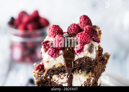 Cheesecake brownies avec framboises empilées sur une plaque. Chocolat fondu. Morceau de gâteau. Dessert Brownie. Cerise et framboise. Saint Valentin. Femmes Banque D'Images