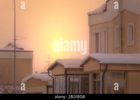 aube jaune-rouge d'hiver dans un aménagement de petite taille de chalet, chute de neige et non pas le bruit numérique ou grain, flou ou flou de mise au point Banque D'Images