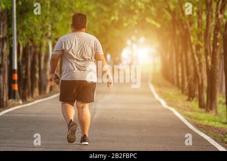 L'exercice et le concept sain : Fat man courir dans le parc Banque D'Images