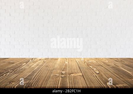 Planche ou table en bois vide avec fond de mur de briques blanches floues abstrait. Pour le montage photo d'écran ou de produit Banque D'Images