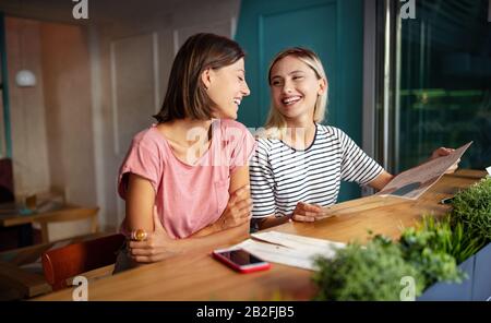 Jeune femme amis parler, sourire et s'amuser ensemble Banque D'Images