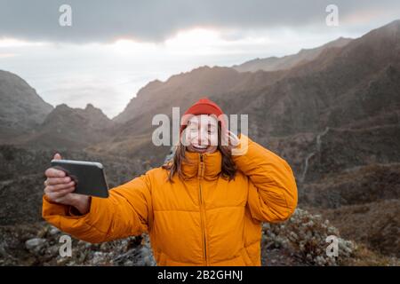 Portrait d'un jeune voyageur vêtu d'une veste et d'un chapeau lumineux pour un voyage en montagne, voyageant sur l'île de Tenerife, Espagne Banque D'Images