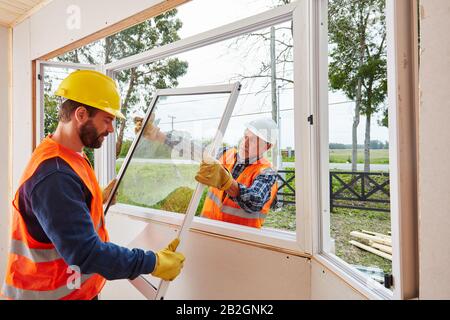 Deux installateurs de Glaserei construisent des fenêtres lors de la construction d'une maison sur un site de construction Banque D'Images