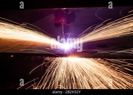 Découpe au plasma de métal avec cnc. Machine à découper le plasma en tôle d'acier. Découpe laser en production. Découpe de métaux industriels par laser plasma. Les étincelles volent depuis le laser Banque D'Images