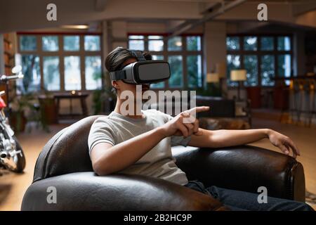 Jeune homme utilisant un casque VR Banque D'Images