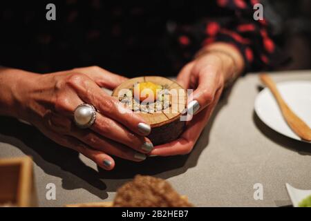 Femme tient une entrée amusante-bouche dans ses mains au restaurant Venissa, cuisine et repas sur les îles de Mazzorbo et Burano, Venise, Italie Banque D'Images