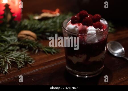 Un dessert végétalien au chocolat, à la crème et aux cerises sur une table décorée de Noël Banque D'Images