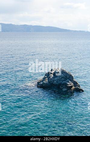 Vue sur le paysage de la mer Égée et de belles îles montagneuses avec une falaise au premier plan contre ciel bleu nuageux le jour ensoleillé de l'été de Datca Banque D'Images