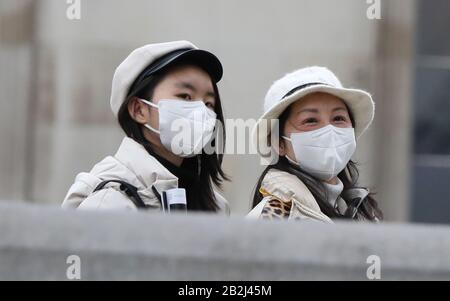 Deux femmes traversent Trafalgar Square de Londres en portant des masques protecteurs le jour où le secrétaire de Heath Matt Hancock a déclaré que le nombre de personnes diagnostiquées avec le coronavirus au Royaume-Uni est passé à 51. Banque D'Images