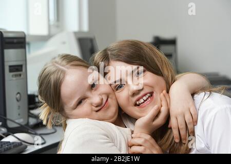 Portrait de deux sœurs (10-15) embrassant Banque D'Images