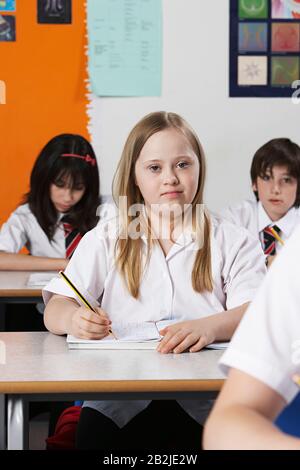 Portrait de fille (10-12) avec syndrome De Down en classe Banque D'Images
