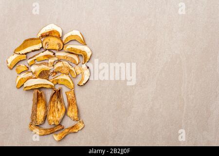 Champignons secs boletus edulis (pain penny, cep, porcino). Ingrédient pour la nourriture végétarienne (végétalienne). Sur fond de pierre, mis en forme d'um Banque D'Images