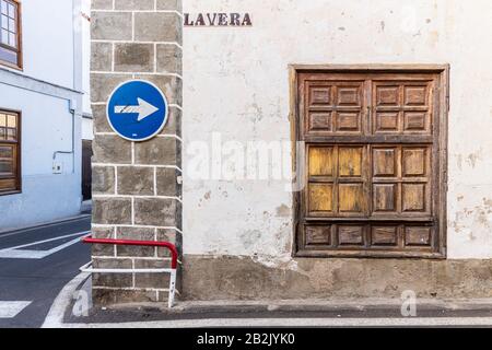 Panneau de signalisation à sens unique sur le vieux mur à côté de la fenêtre avec volets en bois dans la rue la Vera à Guia de Isora, Tenerife, îles Canaries, Espagne Banque D'Images