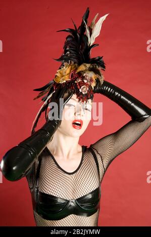 Portrait d'une femme en pin portant un coiffures de plumes sur un fond coloré Banque D'Images