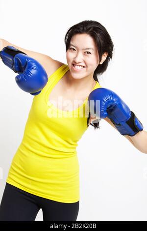 Portrait du boxeur asiatique heureux portant des gants bleus sur fond blanc Banque D'Images