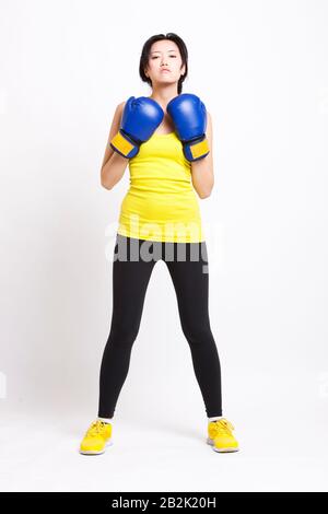 Portrait d'une femme asiatique confiante portant des gants de boxe sur fond blanc Banque D'Images