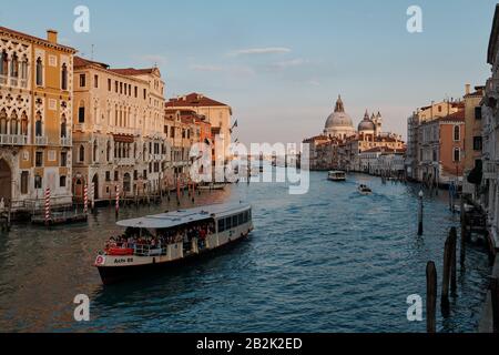 Vaporetto qui traverse le Grand Canal et en arrière-plan Basilique Santa Maria della Salute Banque D'Images