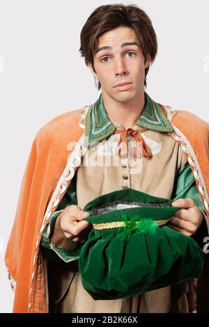 Portrait du jeune homme en costume à l'ancienne mendier sur fond gris Banque D'Images