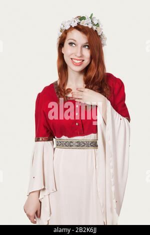 Jeune femme en costume de princesse à l'ancienne regardant loin sur fond gris Banque D'Images