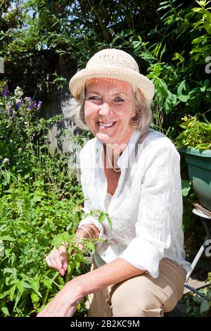 Portrait of senior woman gardening in backyard Banque D'Images