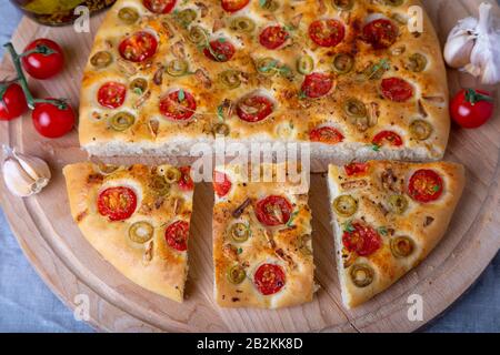 Focaccia avec tomates et olives. Pain italien traditionnel. Cuisson maison. Gros plan, mise au point sélective. Banque D'Images