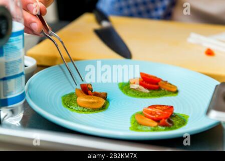 Le chef du restaurant prépare un plat, il termine le plat sur une assiette Banque D'Images