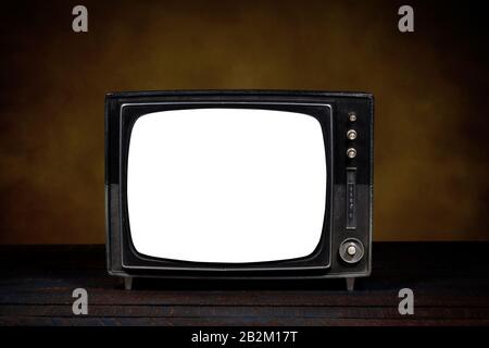 Ancienne télévision portable, avec écran vide. Table en bois et fond marron. Version horizontale. Concept d'obsolescence, de modernisation ou de technolog Banque D'Images