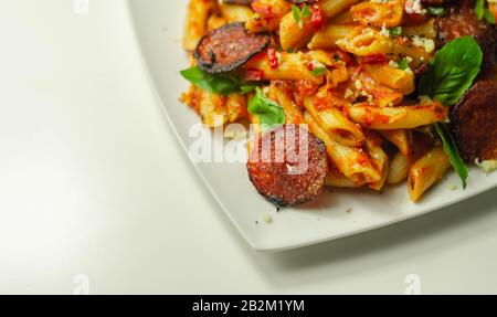 Pâtes de pennette dans une sauce tomate épicée avec pepperoni tranché, mozzarella, et fromage cheddar mûr, cuisine italienne Banque D'Images