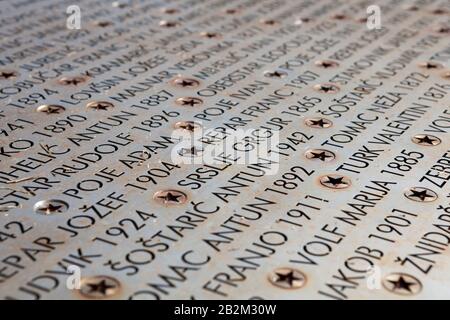 Plaque métallique portant les noms de 1433 victimes du camp de concération Kampor. Cimetière Commémoratif Kampor, Île De Rab, Croatie Banque D'Images