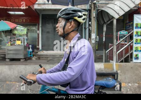 Samut PRAKAN, THAÏLANDE, SEP 21 2019, cycliste avec casque poussant la bicyclette sur la rue de la ville. Banque D'Images