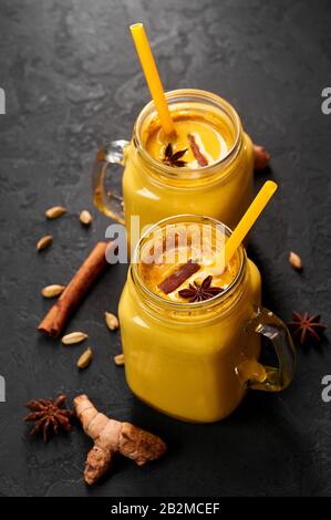 Hadi Doodh connu comme Lait Turmeric doré dans Le Pot Mason sur fond d'ardoise noire. Le Lait d'or est la recette ayurvédique du lait chaud avec du curcuma, du gingembre et Banque D'Images