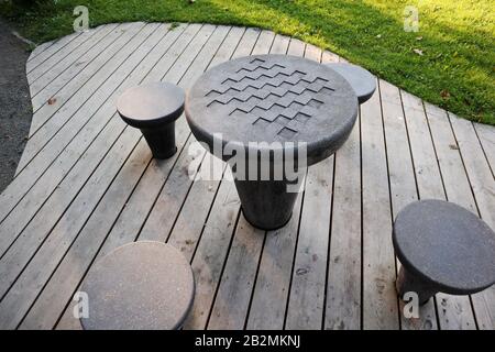 Les tables en béton des Échecs dans la zone de loisirs du parc de la ville pour jouer aux jeux d'échecs sur le parquet et l'herbe verte Banque D'Images