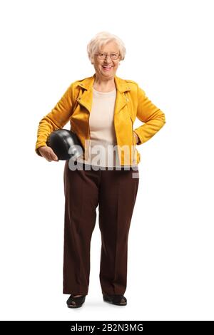 Portrait complet d'une femme senior cool portant une veste en cuir jaune et tenant un casque isolé sur fond blanc Banque D'Images