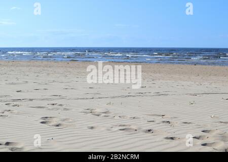 Sable ondulé sur la côte de la mer baltique avec vagues et ciel bleu Banque D'Images