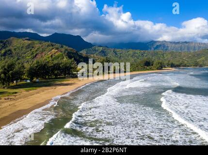 Image panoramique aérienne au lever du soleil au large de la côte au-dessus de la baie Hanalei et du parc de plage Waioli sur l'île hawaïenne de Kauai Banque D'Images