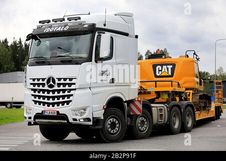 Le camion Mercedes-Benz Arocs 4163 blanc de Kuljetus Isotalo transporte une pelle hydraulique à chenilles CAT sur la remorque le long de la route de Lieto, en Finlande. 23 Août 2019. Banque D'Images