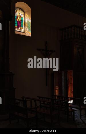 Lumière du soleil à travers une petite fenêtre vitrail avec Saint Joseph, San Jose, au-dessus de la porte d'entrée d'une église à Guia de Isora, Tenerife, Canar Banque D'Images